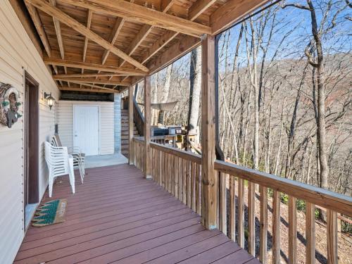 a wooden porch with a table and chairs on it at Lazy Bear Retreat Mountain Views-Hot Tub-FirePit in Whittier
