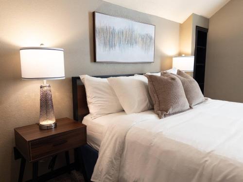 a bedroom with a white bed with two lamps on a table at Your Family’s Home Away from Home w/ No Extra Fees in Broken Arrow