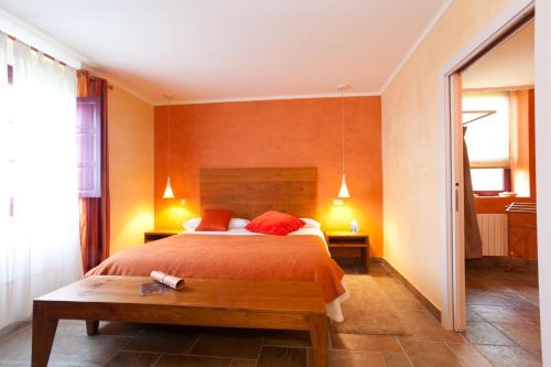 a bedroom with a large bed with orange walls at Casa Rural Etxegorri in Orozko