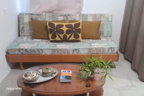 a bed with pillows and a table in a room at Studio Vaipuna, Pirae, Tahiti in Pirae