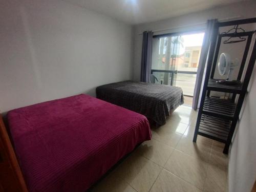 a bedroom with two beds and a large window at Casa Duplex com Vista pro Mar in Guaratuba