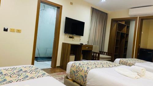 a hotel room with two beds and a flat screen tv at Golden Season Hotel in Cairo