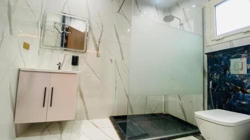 a bathroom with a shower and a toilet and a sink at Golden Season Hotel in Cairo