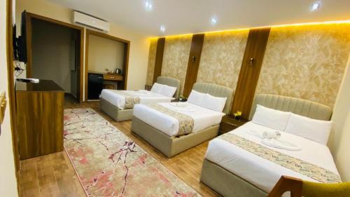 a hotel room with two beds and a television at Golden Season Hotel in Cairo