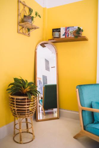 a mirror in a room with a chair and a plant at Baan Pila in Luang Prabang