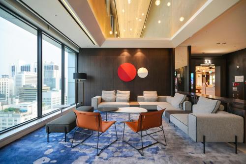 a living room with a couch and a table and chairs at Solaria Nishitetsu Hotel Seoul Myeongdong - Renovated in 2025 in Seoul