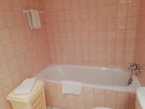 a bathroom with a white tub and a toilet at Charming Chalet with Swimming Pool in Quend in Quend