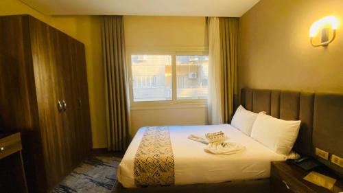 a hotel room with a bed with two towels on it at Golden Season Hotel in Cairo