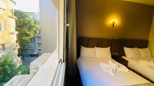 a bedroom with two beds and a large window at Golden Season Hotel in Cairo