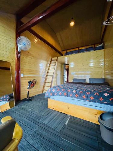 a bedroom with a bed in a wooden room at Săn Mây Homestay and Coffee Măng Đen in Kon Tum