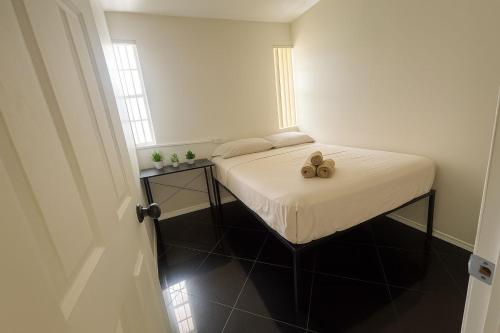 a small bedroom with a bed with a teddy bear on it at Casa Rosa Wynwood in Miami