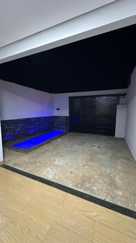 an empty room with a wooden floor and a black door at Excelente casa com piscina e 2 quartos proximo da rodoviária e aeroporto in Palmas