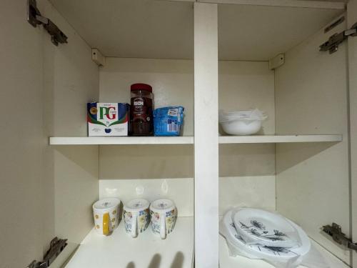 a shelf with cups and other items on it at A cozy and spacious apartment in Dudley