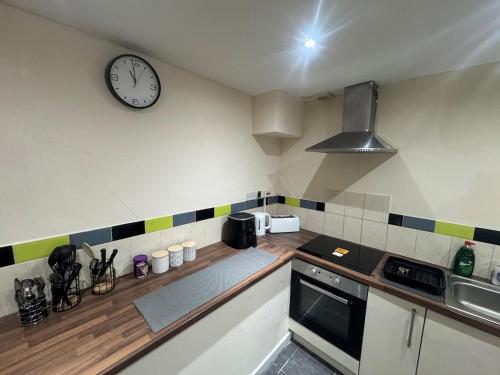 a kitchen with a clock on the wall at A cozy and spacious apartment in Dudley