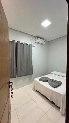 a white room with a bed and a window at Excelente casa com piscina e 2 quartos proximo da rodoviária e aeroporto in Palmas