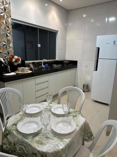 a kitchen with a table with plates and glasses on it at Excelente casa com piscina e 2 quartos proximo da rodoviária e aeroporto in Palmas