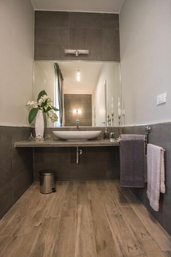 a bathroom with a sink and a large mirror at Casa Vacanze La Mattonara in Viterbo