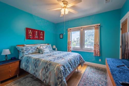 a blue bedroom with a bed and a window at Crafty Oak House in Paso Robles