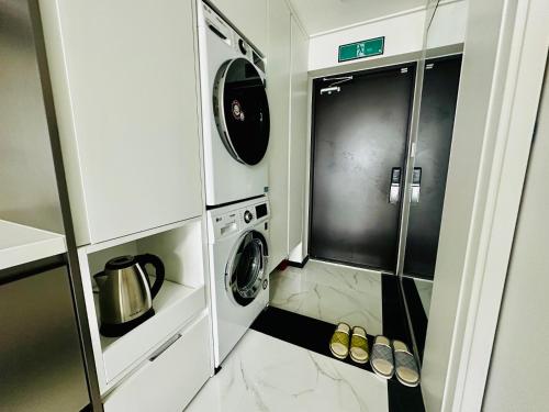 a small kitchen with a washer and dryer at High-rise Beach Home in Busan in Busan