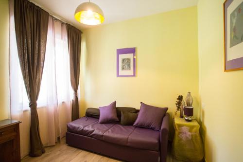 a living room with a purple couch in front of a window at Casa Vacanze La Mattonara in Viterbo