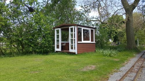 a small cabin in the middle of a grass field at Watermill Farm Cottages in Metheringham