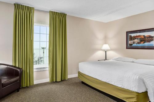 a bedroom with a bed and a window with green curtains at Second Floor Deluxe Suite Bay View in North East