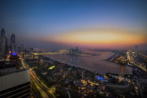an aerial view of a city at night at Maison Privee - Chic Coastal Escape with Open Sea Vws on Palm Entry in Dubai