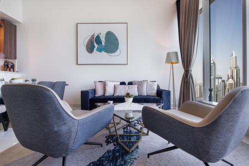 a living room with two chairs and a couch at Maison Privee - Chic Coastal Escape with Open Sea Vws on Palm Entry in Dubai