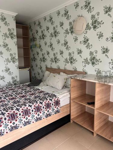a bedroom with a bed and floral wallpaper at Podsolnukhi Guest House in Cholpon-Ata