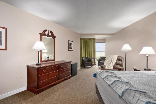 a hotel room with a bed and a dresser and a mirror at Center Parlor Room at Sandy Cove Unit in North East