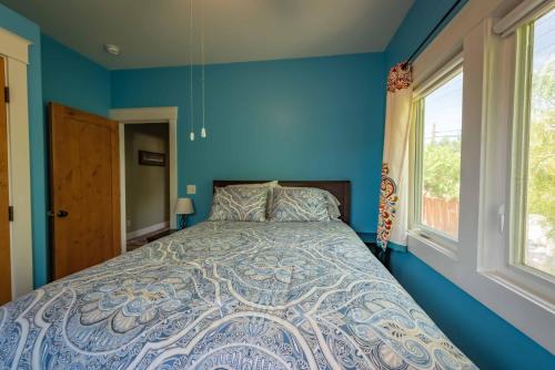 a blue bedroom with a bed and a window at Crafty Oak House in Paso Robles