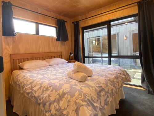 a bedroom with a bed with two towels on it at Brand New 4BR Alpine Home Near Turoa Ski Field in Ohakune