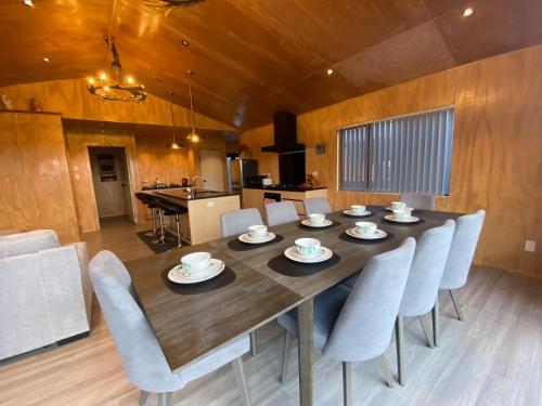 a dining room with a large wooden table and chairs at Brand New 4BR Alpine Home Near Turoa Ski Field in Ohakune