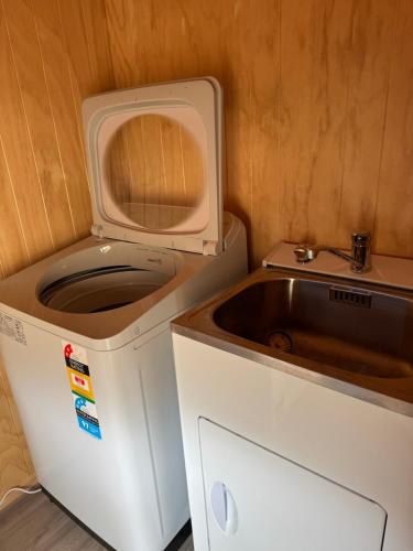 a small kitchen with a sink and a microwave at Brand New 4BR Alpine Home Near Turoa Ski Field in Ohakune