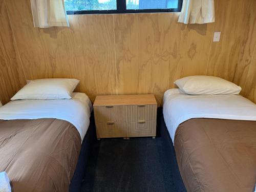 a room with two beds and a table between them at Brand New 4BR Alpine Home Near Turoa Ski Field in Ohakune