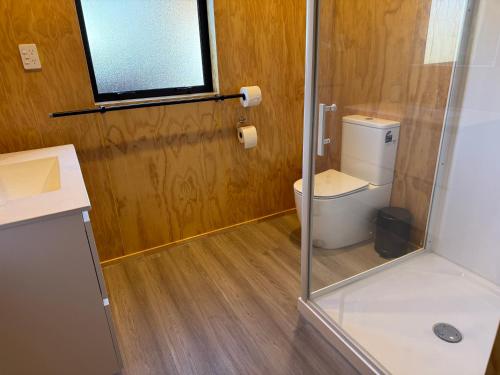 a bathroom with a toilet and a glass shower at Brand New 4BR Alpine Home Near Turoa Ski Field in Ohakune