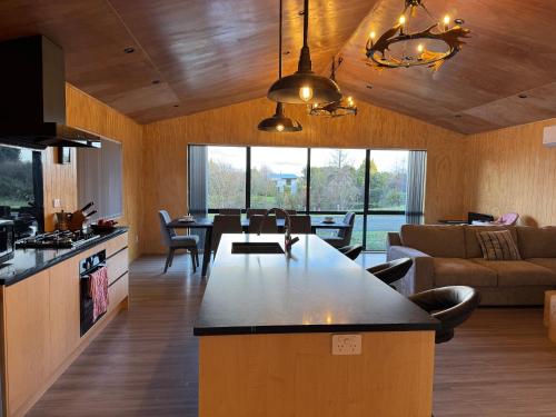 a kitchen and living room with a large island at Brand New 4BR Alpine Home Near Turoa Ski Field in Ohakune