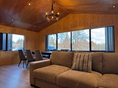 a living room with a couch and a table with chairs at Brand New 4BR Alpine Home Near Turoa Ski Field in Ohakune