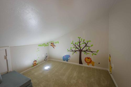 a childs room with a tree and animals on the wall at Casa del Lago in Atascadero