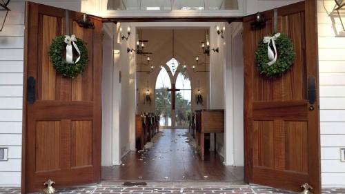 a hallway with two wooden doors with wreaths on them at Signature 4 Bedroom Residence 1033 in Bluffton