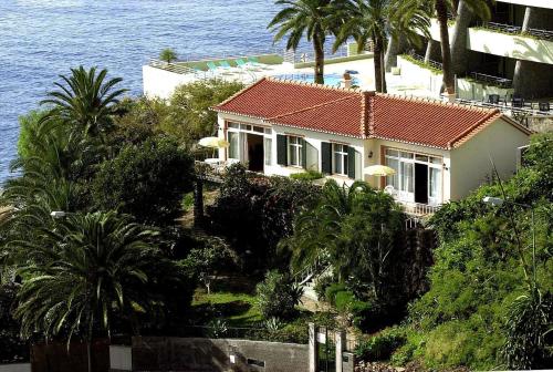 a house on a hill next to the ocean at Vila Calaça in Funchal