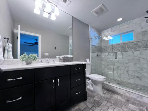 a bathroom with a sink and a toilet and a shower at Fabulous 6 bedroom (3 master suites), 4 bath pool w/Jacuzzi home in Orange