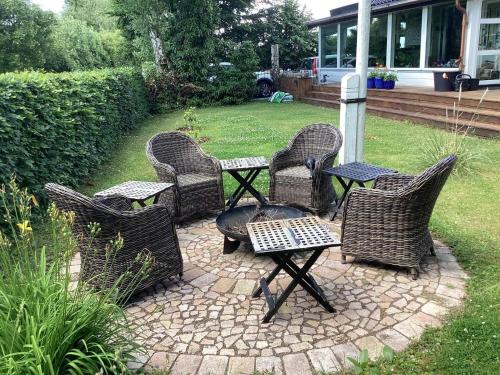 a group of wicker chairs and tables on a patio at 10 person holiday home in Maribo in Maribo