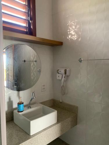a bathroom with a sink and a mirror at Chalé Village da Serra in Serra de São Bento