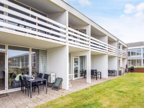 a house with a patio with a table and chairs at 7 person holiday home in Ringkøbing in Ringkøbing