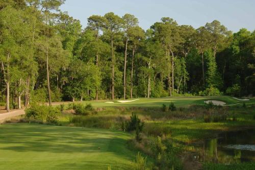 a golf course with a green and a pond at Signature 4 Bedroom Residence 1033 in Bluffton