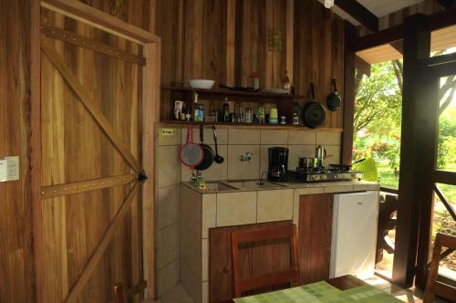 a kitchen with wooden walls and a stove and a door at Las Brisas del Sur in Ojochal
