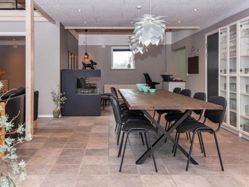 a dining room with a large wooden table and chairs at 4 star holiday home in Henne in Henne