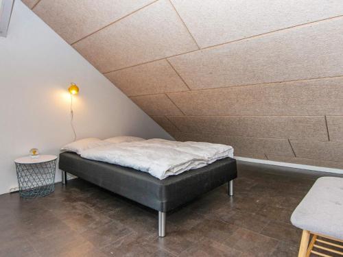 a bed in a room with a ceiling at 4 star holiday home in Henne in Henne