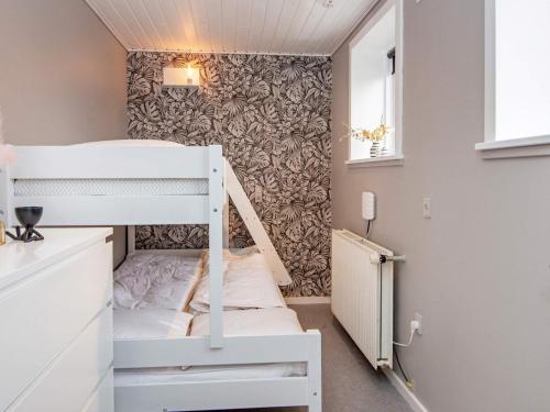 a small room with a bunk bed and a wall with a wallpaper at 4 star holiday home in Henne in Henne